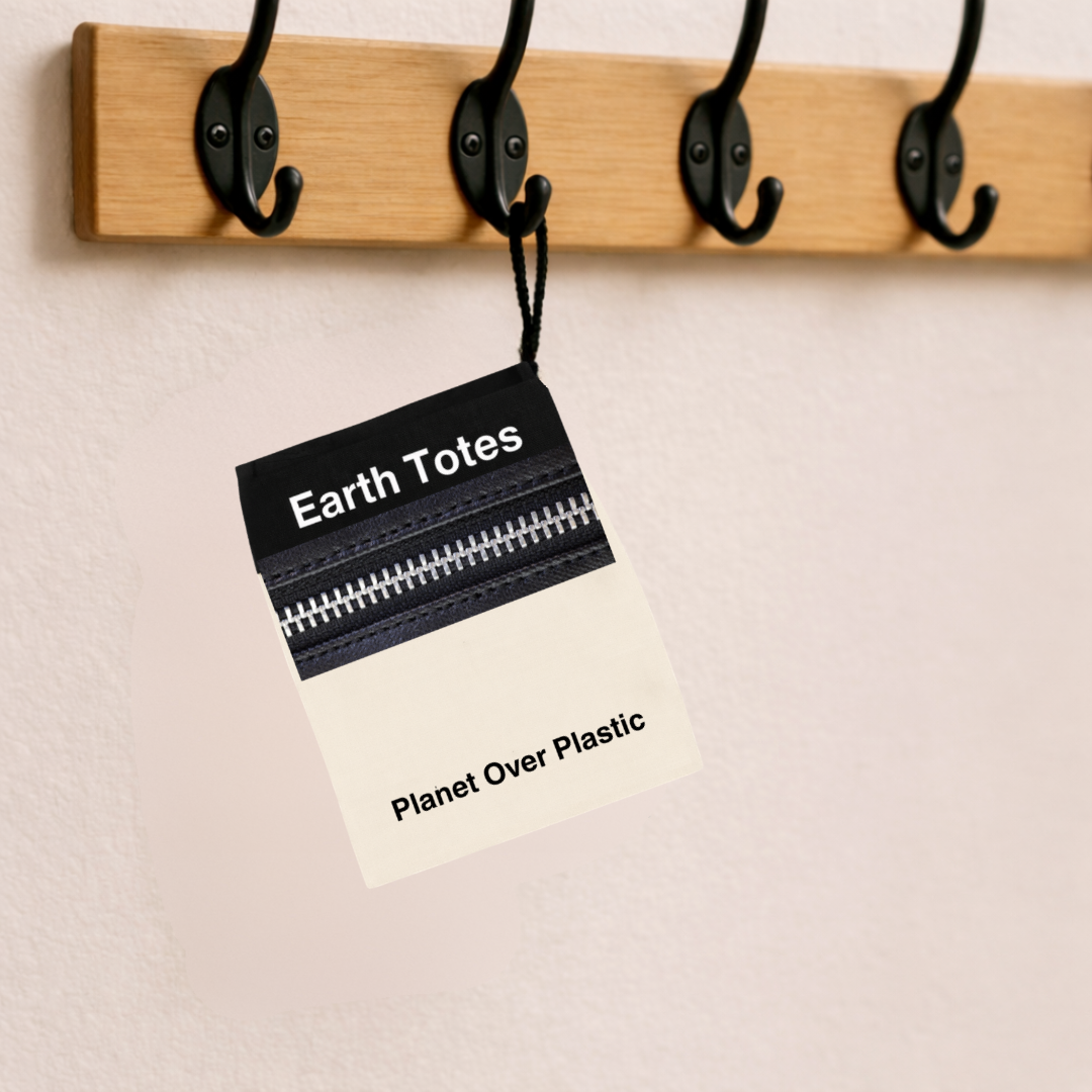Black tote mesh bag with 'Earth Totes Carry The Change' text hanging on a wooden hook rack.